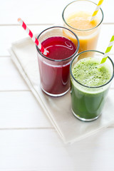 Detox drinks in glass: fresh smoothies from vegetables: beet, pumpkin and spinach on white background