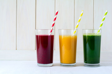 Detox drinks in glass: fresh smoothies from vegetables: beet, pumpkin and spinach on white background