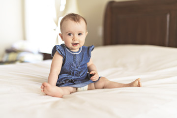 Portrait of a baby on the bed in her room
