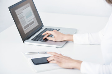 Closeup photo of businesswoman's hand on keyboard and touch screen