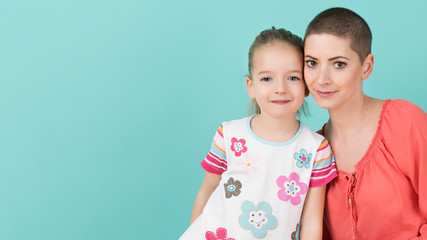 Cute preschool age girl with her mother, young cancer patient in remission. Cancer patient and family support concept.