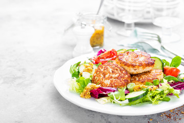 Cutlets and fresh vegetable salad on white plate. Fried meatballs with vegetable salad