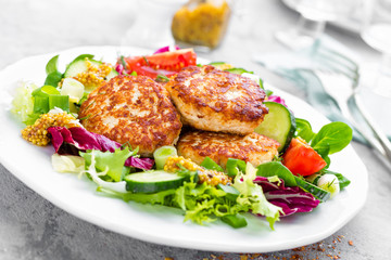 Cutlets and fresh vegetable salad on white plate. Fried meatballs with vegetable salad