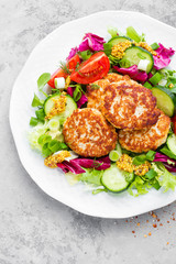 Cutlets and fresh vegetable salad on white plate. Fried meatballs with vegetable salad