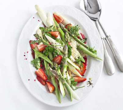 asparagus salad with strawberries on white plate