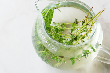 Steaming Herbal Tea in Glass Teapot with  Leaves