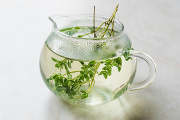 Steaming Herbal Tea in Glass Teapot with  Leaves