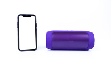 Purple Wireless bluetooth speaker with new smartphone isolated on white backgrou