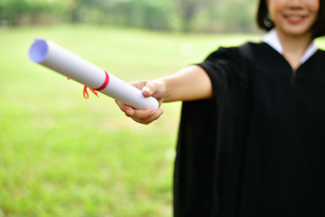 Graduation Concept. Graduated students on graduation day. Asian students are smiling happily on the graduation day. Students wear graduation gowns in the garden