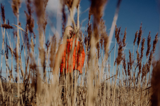 Mann mit roter Jacke im Schilf