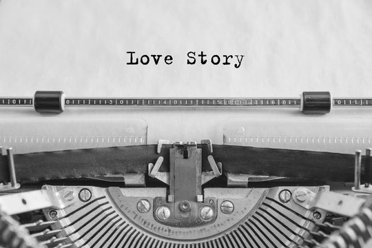 love story text is typed on an old vintage typewriter with white paper. love sign