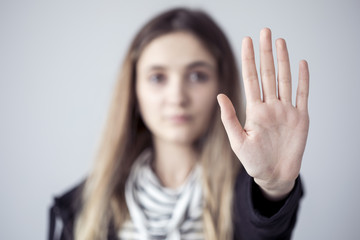 Young woman showing stop gesture open palm hand