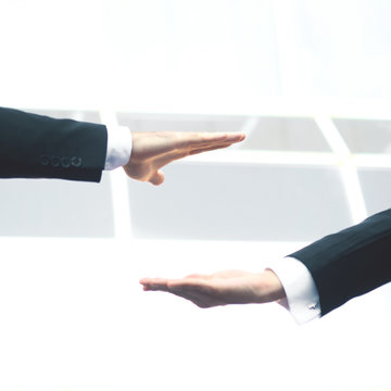 close up.two businessmen stretching out their hands towards each other