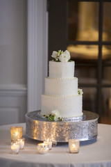 Beautiful three tiered wedding cake with candles.