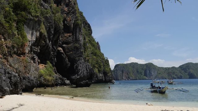 Island front and boats on tropical beach of El Nido