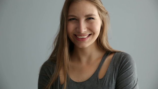 portrait of a blond girl of European appearance in casual clothes on a gray background