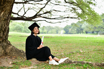 Graduation Concept. Graduated students on graduation day. Asian students are smiling happily on the graduation day. Students wear graduation gowns in the garden