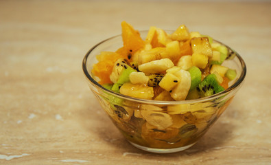 Bowl of healthy fresh fruit salad on stone background