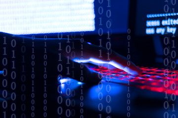 A computer programmer or hacker prints a code on a laptop keyboard to break into a secret organization system.