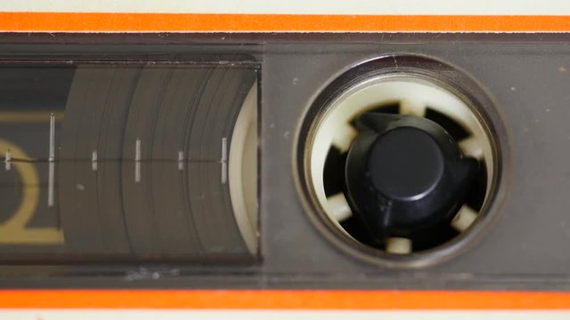 Close up of audio cassette tape in use sound recording in a cassette player. Deck Cassette Tape Macro