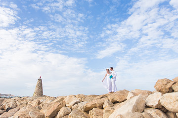 Obraz premium Bride and groom by the sea on their wedding day