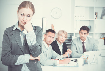 Fototapeta premium Business woman crying in office with working colleagues