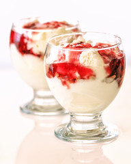 Natural yogurt cold with strawberry jam in two glasses on the table. Close-up.