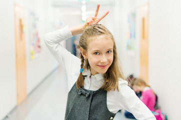 Funny cute girl at break time in school.