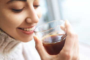 young woman drinks coffee in cafe