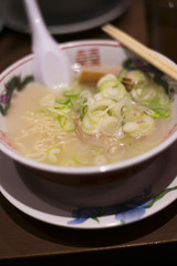 Heap of green chopped onions on top of a bowl of Japanese ramen