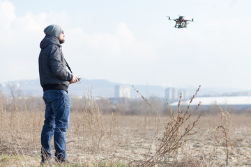 drone user piloting a drone - obrazy, fototapety, plakaty