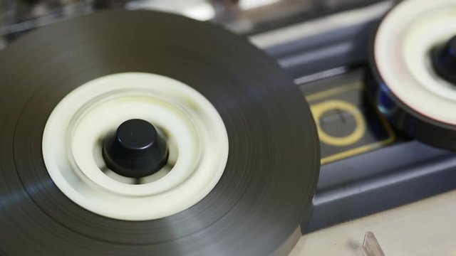 Close up of reel to reel mechanism playbacks. Music Tape. Coated with a metallic compound that is capable of storing the pattern of magnetization. Rotation reel with magnetic tape on recorder / player