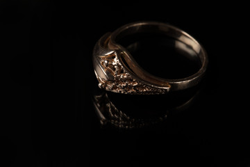 Gold ring with a pattern on a black background