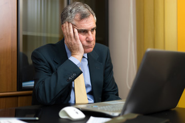 Bored businessman in front of his laptop