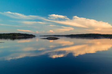 Obraz na płótnie Canvas Reflection of clouds in the water. Islands on the horizon. Wild nature. Calm on the lake. Karelia Ladoga Lake.