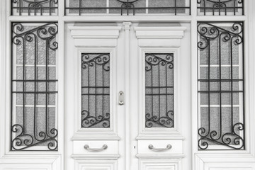 Entrance with wrought-iron tracery lattice on the windows.