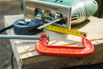 Measuring tape, clamp and electric wood saw