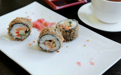 Rolls on a white square plate on a wooden table. Top view.