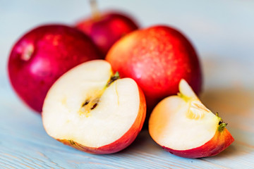Apples whole and cut on blue wooden surface
