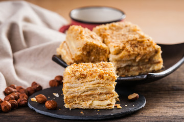 Slices of sweet classic layered cake Napoleon and hazelnuts