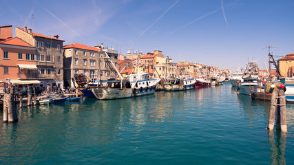 Fishing boats moored in a canal in Chioggia, Italy.