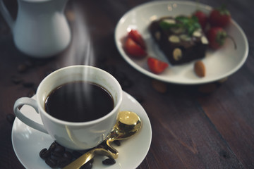 Hot coffee in white cup on wood background,Brownie with Fresh strawberry on white plate