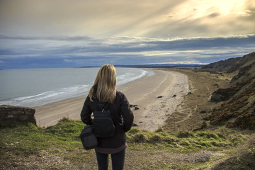 Woman is looking at the seashore. St Cyrus beach, Aberdeenshire, Scotland, UK. 