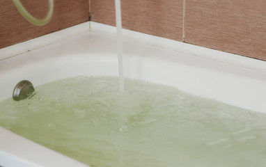 Water poured into the tub. Full bath. Close up.