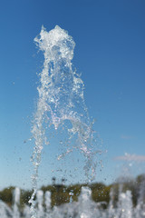 Naklejka na ściany i meble Splash water fountain on blue sky background