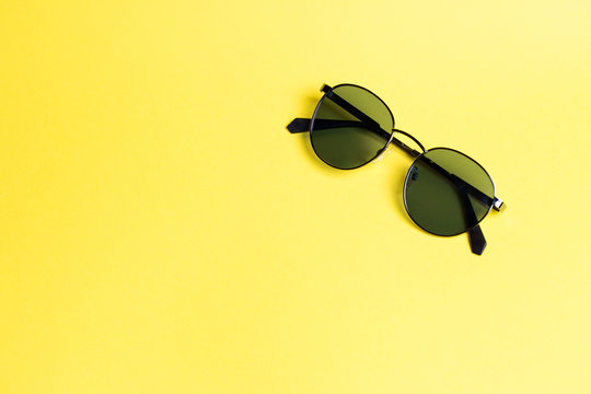 sunglasses on a yellow isolated background close-up On the right in a corner