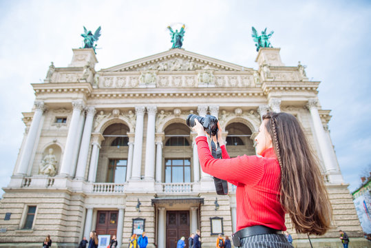 tourist woman taking picture of old european building. travel concept. copy space