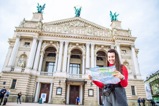 tourist woman with map stand in front of old european building. travel concept. copy space