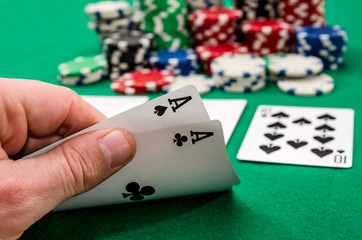 Close up of a poker player holding playing cards .