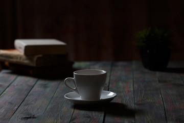A cup of coffee in the workplace on a wooden table. A cup of coffee in the workplace on a wooden table. The concept of working outside the office